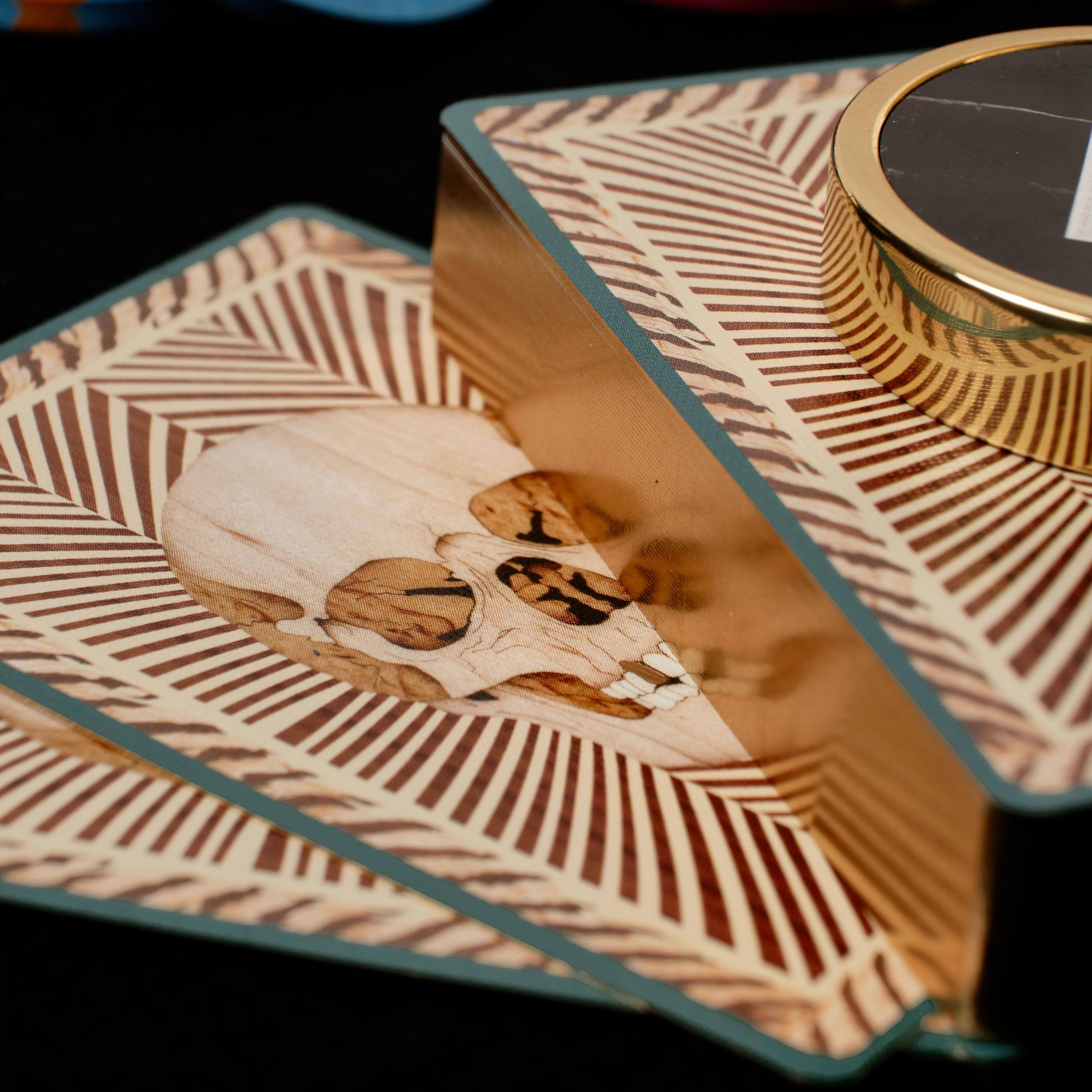 A stack of Skull playing cards besides Poker chips