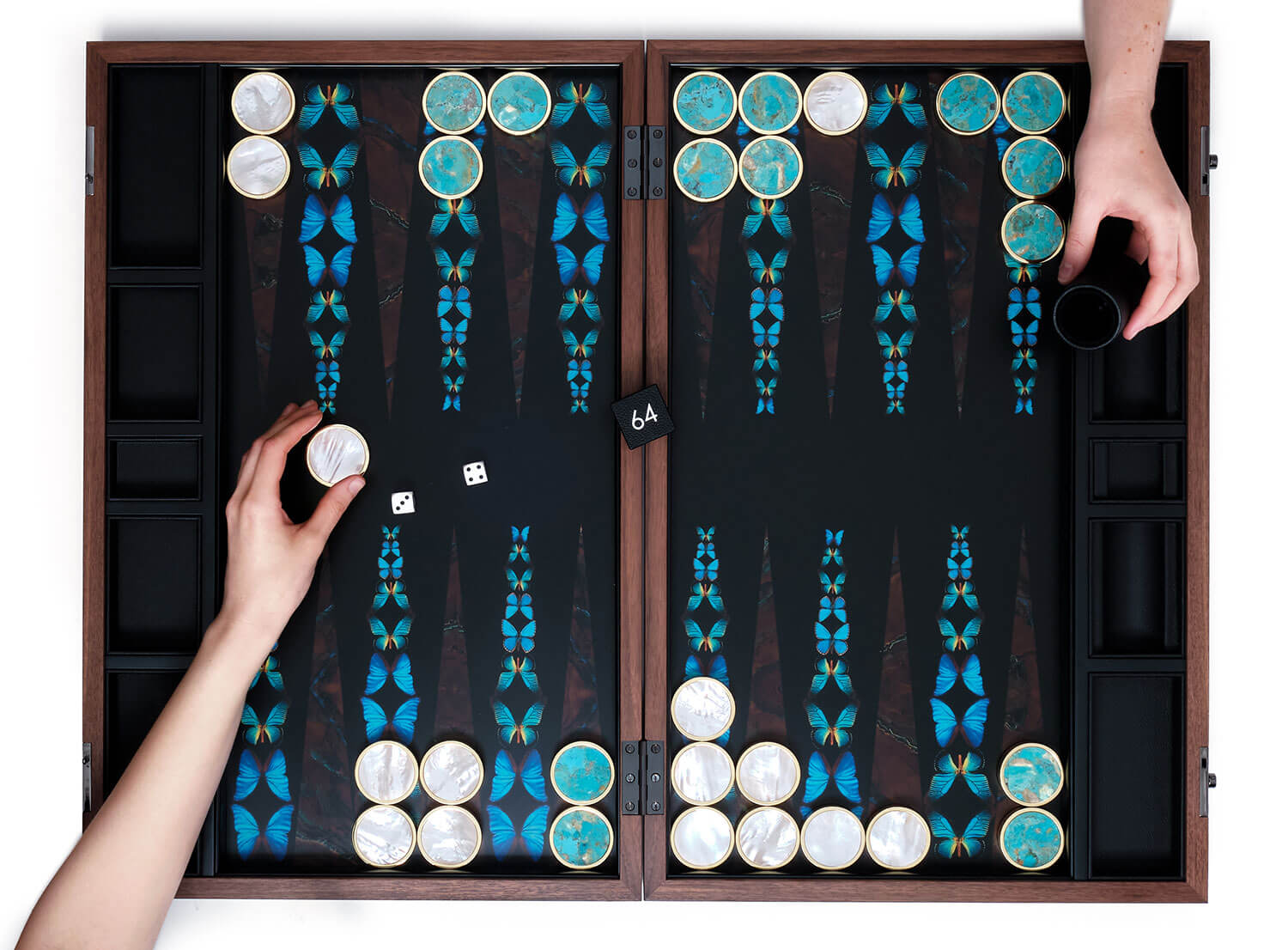 Two people playing a game of Photographic Butterfly backgammon with semi-precious stone playing pieces